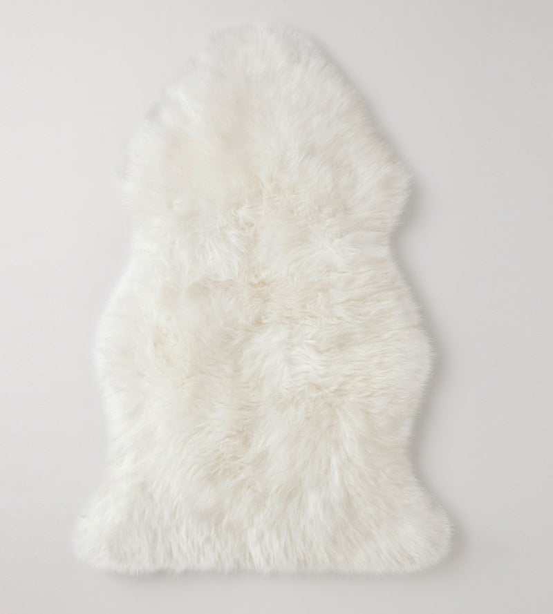 Ivory Sheepskin rug with thick merino wool fur, on a light gray background